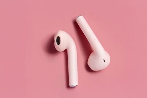 White earbuds on pink background